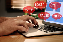 Man Using Laptop And Icons With Offensive Messages, Closeup. Cyber Bulling Concept