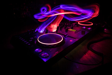 Wall Mural - DJ console deejay-mixing desk in dark with colorful light. Mixer equipment entertainment DJ station.