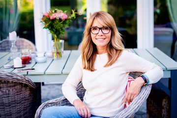 Happy mature woman relaxing at home in the backyard