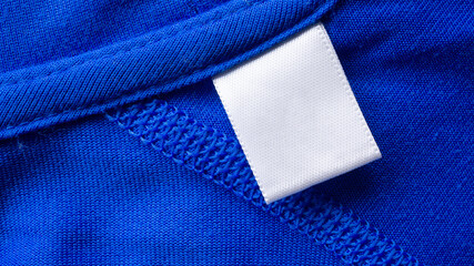 blank white laundry care clothes label on blue fabric texture background