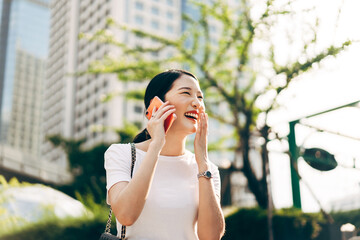 Happy young adult asian business single woman use mobile phone talking with friends.