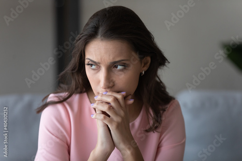 Worried unhappy young indian Arabic woman look in distance window thinking or pondering over problem solution. Upset sad millennial middle eastern female lost in thoughts, feel anxious at home.