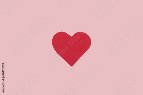 Minimalist picture of a red heart on a pink background