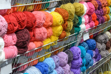 Counter In Shop For Knitting And Needlework With Coils Colored Wool Yarn. Different Bright Colors Threads On Rows In Store. Retail Trade Of Goods For Hobby, Needlework And Knitting. Selective Focus