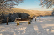 canvas print picture - Mit Schnee bedeckte Holzbank in der Eifellandschaft im Winter. 