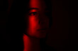 © Piotr Marcinski - The close view of young woman's face illuminated with red light in the dark. Depressed woman suffering because of isolation during coronavirus pandemic, she stays in home. She is sad and lonely.