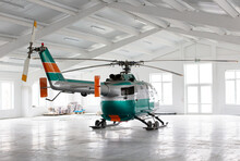 Green And Silver, Helicopter In Light Hangar Against Large Windows.
