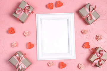 Wall Mural - Empty white frame with gifts, candles hearts and roses on pink background. Valentine's day concept.