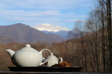 Teapot And Cup Of Tea On The Table With Mountain View