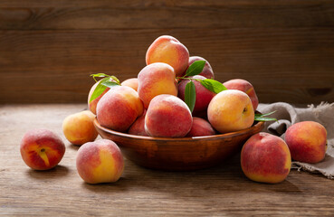 Wall Mural - bowl of fresh peaches on a wooden background