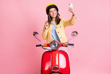 Sticker - Photo of young happy smiling girl woman take selfie on phone wear yellow helmet ride red motorbike isolated on pink color background