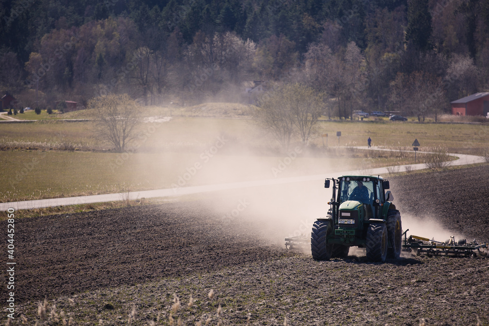 Tractor farmer plowing field ploughing soil farming dust agriculture ...