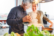 Glückliche Freunde oder Paar beim Kochen von Essen in Küche