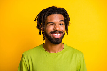 Wall Mural - Portrait of nice satisfied dark skin guy wink eye in camera isolated over vibrant yellow color background