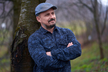 Farmer leaning against tree