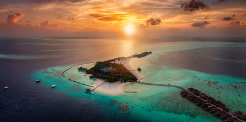 Wall Mural - Aerial view of a beautiful paradise island in the Maldives, Indian Ocean, during a colorful sunset