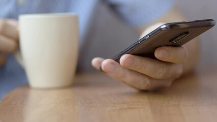 Close-up hands of a man using smartphone. He is typing message on mobile phone.