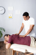© LIGHTFIELD STUDIOS - african american masseur massaging back of middle aged man on massage table