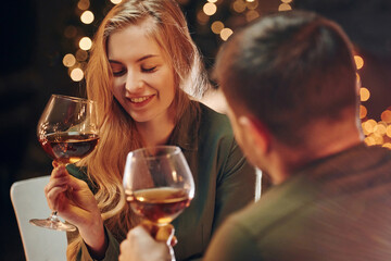 Tasting wine. Young lovely couple have romantic dinner indoors together