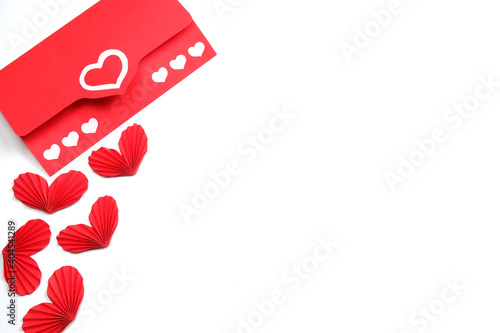 Envelope from red paper with hearts and few handmade red accordion folded paper hearts on white background isolated. Love, Valentine's, mother's, women's day, relations, wedding, romantic template 