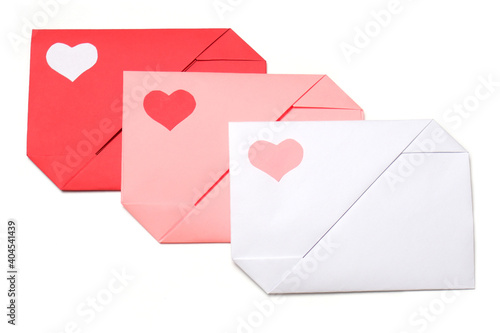 Red, pink, white paper envelopes with colored hearts on white background isolated. Love, Valentine's, mother's, women's day, relations, wedding, romantic concept 