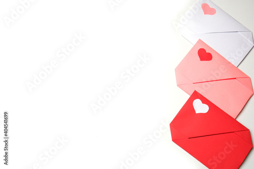 Red, pink, white paper envelopes with colored hearts on white background copy space. Love, Valentine's, mother's, women's day, relations, wedding, romantic concept 