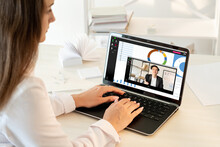 Video Chat. Remote Education. Distance Learning. Virtual Class. Female Student Watching Online Course Of Asian Male Business Coach On Laptop Screen At Light Home Workplace.
