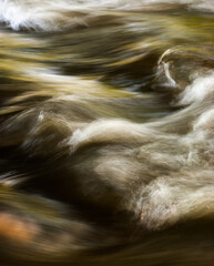 Close up abstract motion blue of waves in river with ripples colors and moving water