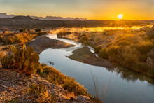 A Prickly Pear Cactus And The Sun Rising Over Distance Mountains And A River Meandering Below, Rio Grande River, Big Bend National Park, Texas