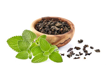 Heap of dry  green tea and fresh peppermint on background, isolated on white. Fresh lemon balm leaves, melissa isolated on white background.