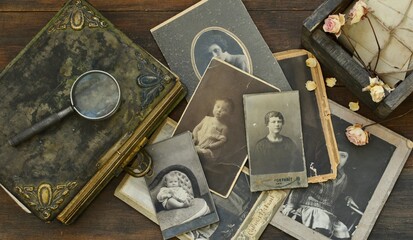 still-life with old photo album and historical photos of family