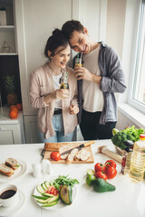 Adorable couple smiling while drinking fresh juice and eating vegetable in the kitchen