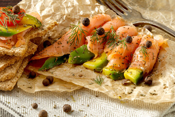 Sticker - Fresh salmon with avocado for breakfast, on a wooden table in the light of the morning sun