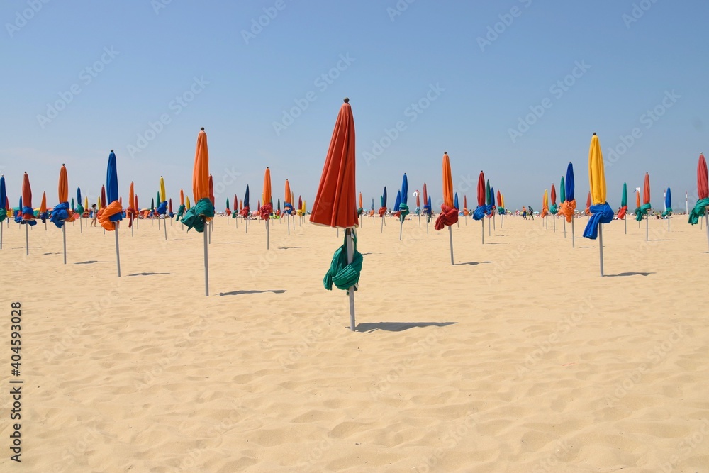 Folded Beach Umbrellas Against Clear Sky - obrazy, fototapety, plakaty 