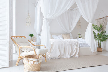 Cozy interior of a bright Balinese-style apartment with white walls, bamboo furniture. bed room with night lights, bed with balanchin and large windows