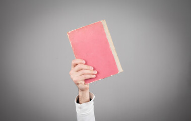 Wall Mural - Male holding book on grey background.