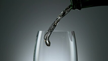 Wall Mural - Camera Movement, Super Slow Motion Detail Shot of Pouring White Wine from Bottle with Old Barrel Wooden Background at 1000fps.