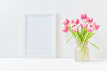 Home Interior With Decor Elements. Mockup With A White Frame And Pink Tulips In A Vase On A Light Background