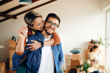 Wall Mural - Happy couple having fun while moving into their new apartment.