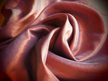 Beautiful Fabric - Taffeta, Neatly Folded In Waves. Crumpled Material That Looks Like Silk Or Brocade. Overflow And Gradient Of Bronze And Pink Color At Different Lighting Angles. Fabric For Curtains