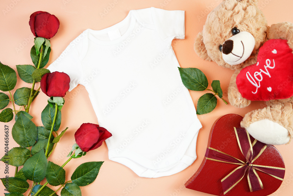 Obraz na płótnie Happy Valentine's Day baby apparel flatlay owith teddy bear, red roses and heart shaped gift on modern coral background. Mock up with negative copy space for your text or design here. w salonie