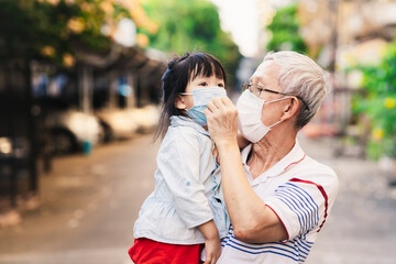 Family wears a surgical face mask. Grandfather carried his granddaughter. Adults care for young children during the coronavirus (COVID-19) outbreak and PM2.5. Living a new way of life in public spaces