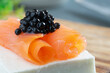 DELICIOUS APPETIZER MADE OF FRESH CHEESE, TWO ROLLS OF SMOKED SALMON AND BELUGA BLACK CAVIAR ROES. GOURMET AND DELICATTESEN PRODUCTS. CLOSE UP.