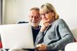 Senior couple reading documents and calculating bills to pay in living room at home.Retirement couple and loan bankruptcy money concept	