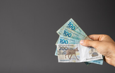 Hand of a man holding Brazilian notes Reais