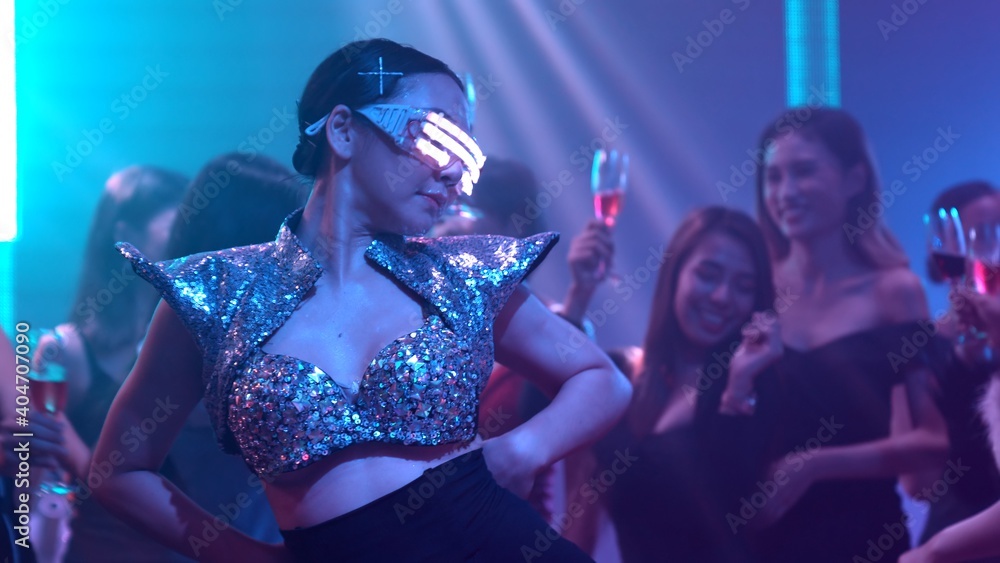 Group of people dance in disco night club to the beat of music from DJ on stage . New year night party and nightlife concept . - obrazy, fototapety, plakaty 