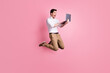 © deagreez - Full length photo portrait of screaming guy jumping up holding laptop isolated on pastel pink colored background