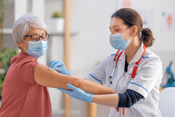 Doctor giving a senior woman a vaccination