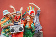 © Alessandro Biascioli - Happy friends celebrating carnival party outdoor - Young crazy people having fun wearing costumes listening music with vintage boombox stereo - Youth holidays culture lifestyle concept