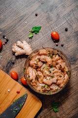 Wall Mural - Raw marinated chicken meat with garlic, ginger and teriyaki sauce in a glass bowl on wooden table